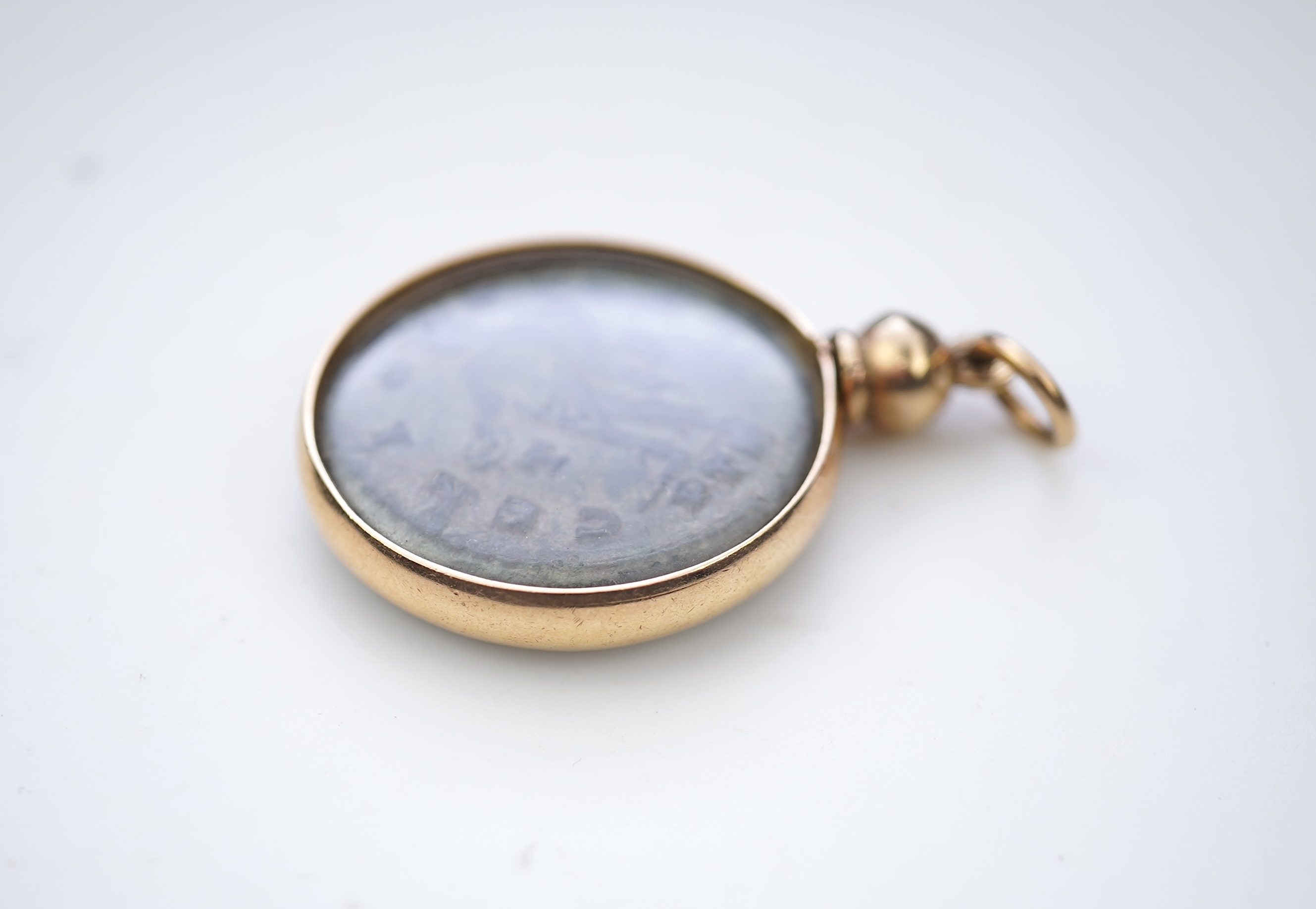A gold and Roman bronze coin pendant